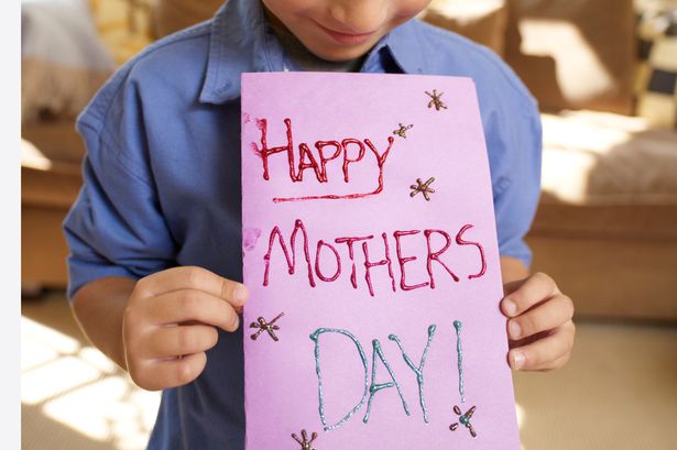 Boy-holding-greeting-card-for-Mothers-Day